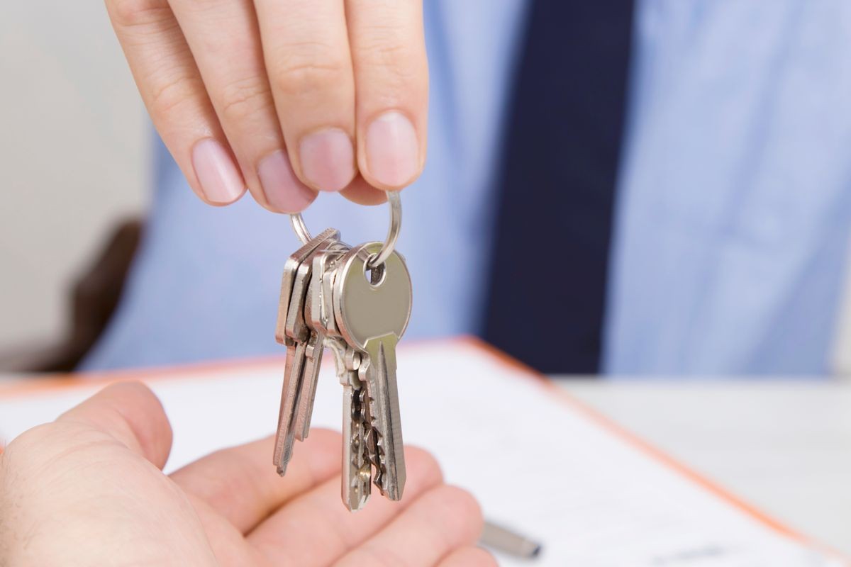 hands with keys, concept of buying or renting house or apartment