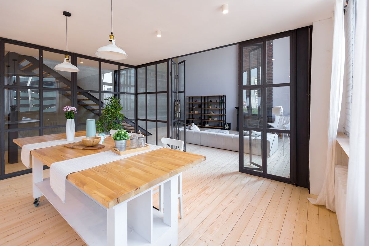 trendy modern design two-level
apartment with large high windows. The stylish living room and kitchen in bright colors are undressed by a glass partition. bedroom on the second floor.